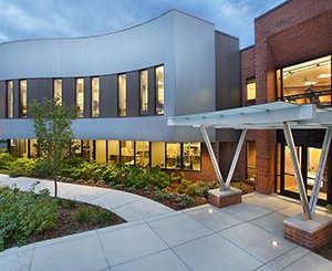 Exterior shot of Medical Office Building. Modern design building at dusk so you can see in the large bright window. Human-centered design by healthcare specialists at TSA Architects.